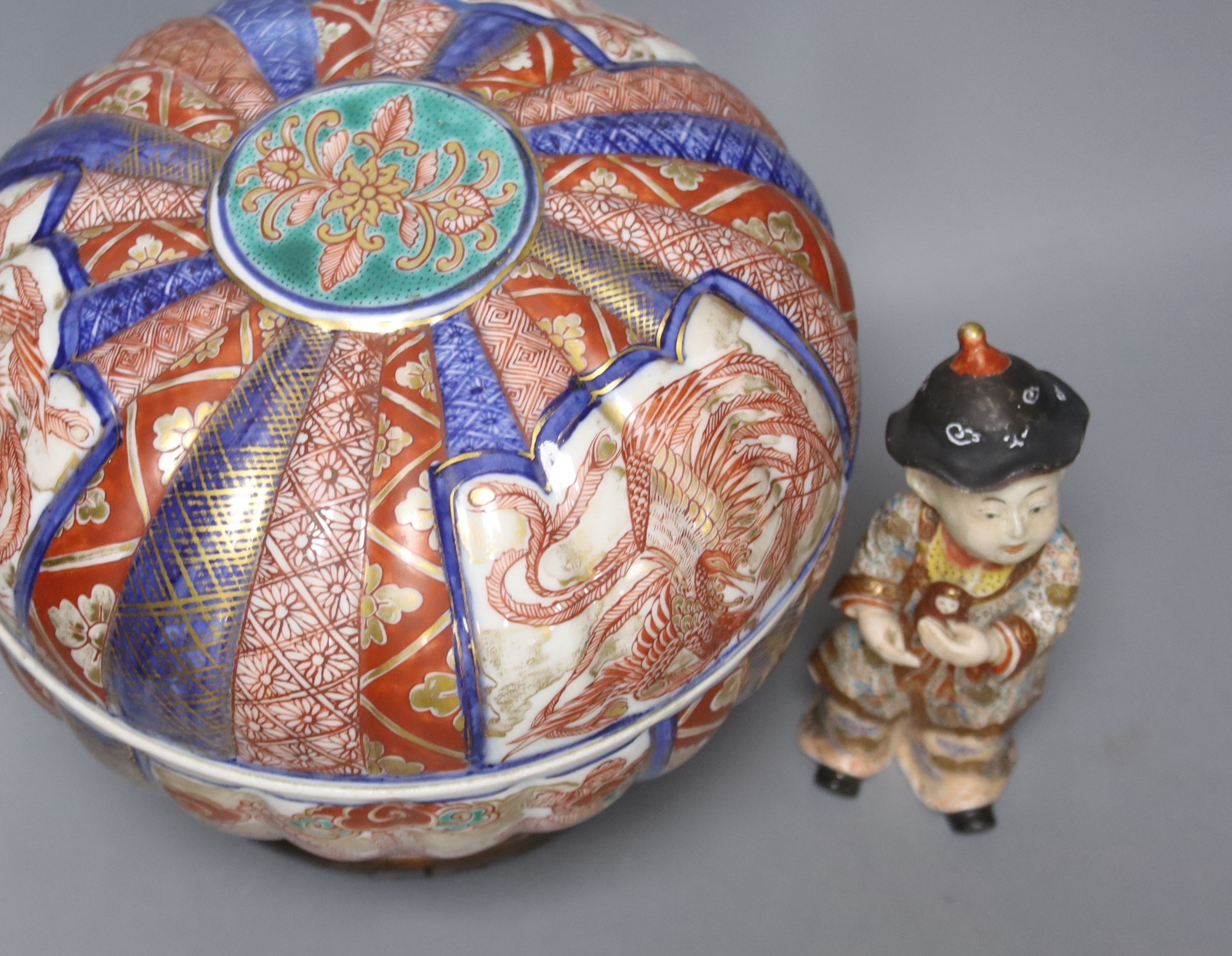 A 19th century Japanese Imari box and cover and a Satsuma pottery figure of a boy holding a Daruma doll, tallest 20cm